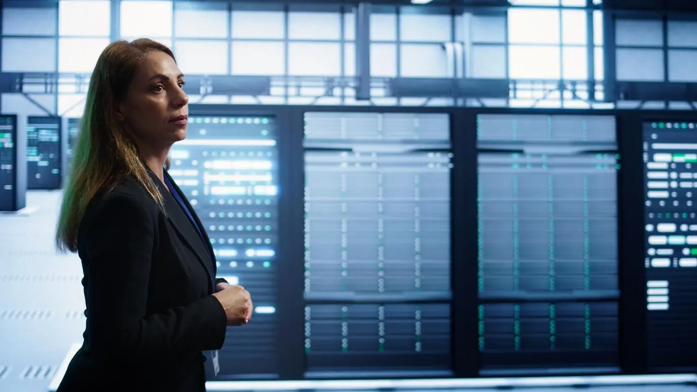 ИТ-специалист контролирует рабочую зону дата-центра, проверяя оборудование.