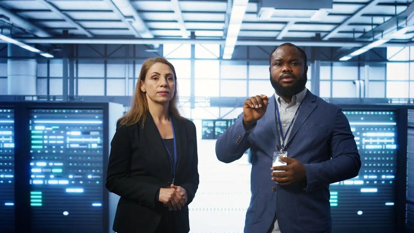 Программист и коллега работают над обеспечением безопасности оборудования серверной, используя дополненную реальность.